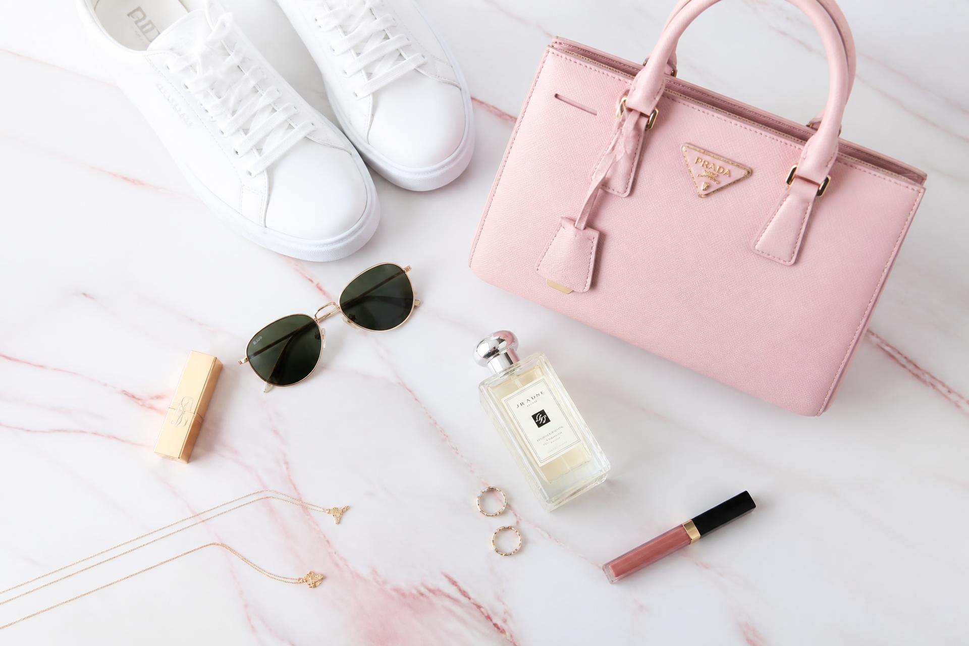 Selección editorial de artículos de lujo: bolsa rosa, tenis blancos, lentes y cosméticos